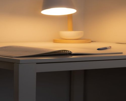 Cozy evening reading setup with a warm desk lamp and a book