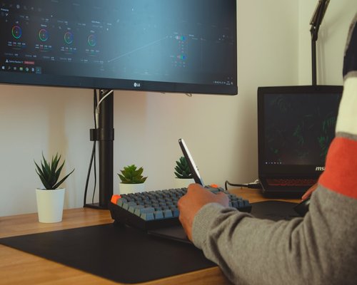 Person adjusting monitor distance in a home office setup